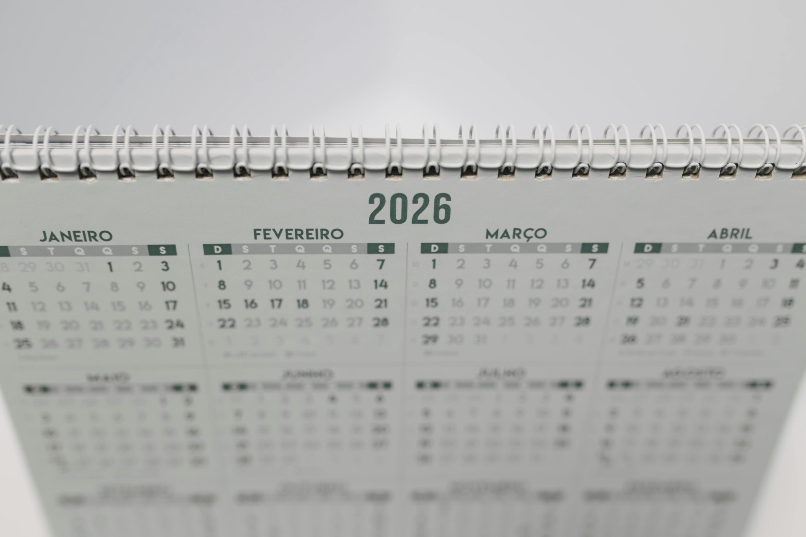 Close-up of a 2026 spiral-bound desk calendar with months in Portuguese.